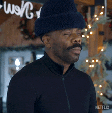 a man wearing a hat and a black shirt with netflix on the bottom right