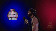 a man singing into a microphone in front of a red bull 64 bars sign
