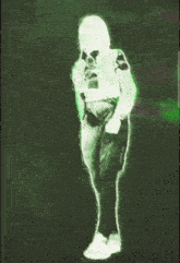 a green and white image of a person standing in the dark