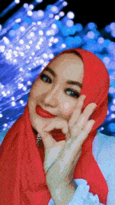 a woman wearing a red head scarf is giving the ok sign