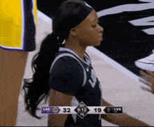 a female basketball player wearing a headband stands on the court during a game between las and lva