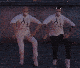 two men wearing white shirts with stethoscopes on them are dancing