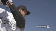 a baseball player with the word rockies on his jersey throws a ball