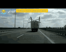 a truck is driving on a highway with a sign that says bardzo mocno placesz ulicol