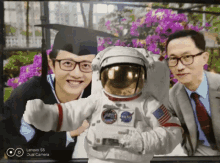 a picture of a man in a graduation cap and gown with an astronaut in front of him