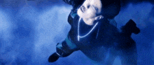 a man is falling through the air in a dark room with a blue background .