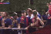 a crowd of people are gathered in front of a live broadcast of a soccer game