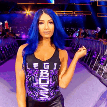 a woman with blue hair is wearing a tank top that says reigns