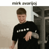 a man wearing a black shirt that says mirk avarijoj