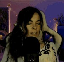 a woman is sitting in front of a microphone wearing headphones .