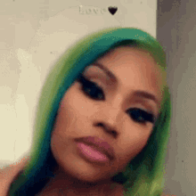 a close up of a woman 's face with green hair and pink lips