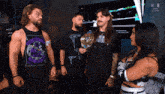 a group of wrestlers standing next to each other with one wearing a purple shirt that says judgment day