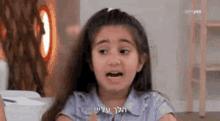 a little girl is making a funny face in a room .