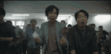 a group of men are standing in a room with one man holding a piece of paper