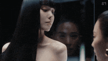 two women are looking at each other with a sm logo in the background