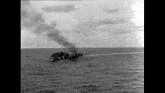 a black and white photo of a ship in the ocean .
