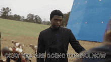a man in a suit stands in a field with the words okay you are going too far now