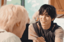 two young men are talking to each other and one is smiling
