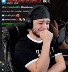 a man wearing headphones is crying while sitting in a chair in front of a microphone .