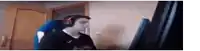 a man wearing headphones is sitting in a chair in front of a computer screen .