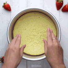 a person is holding a cake in a pan with the word mr.cakes on the bottom