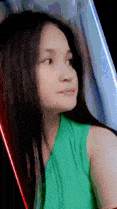 a girl in a green tank top is looking to the side