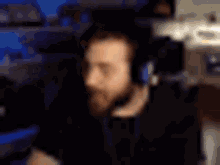 a man with a beard is wearing headphones and making a face .