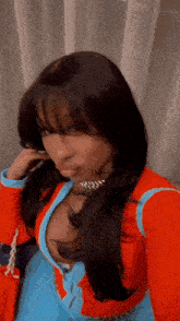 a woman wearing a red and blue outfit is taking a selfie