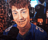 a man wearing headphones and a blue shirt with the letter u on the sleeve