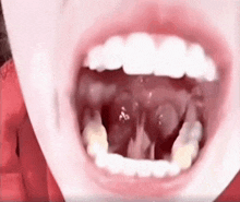 a close up of a person 's mouth with a lot of teeth and a red background .