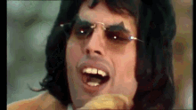 a close up of a man wearing sunglasses and a jacket .