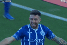 a man in a blue and white striped shirt with the word cata on the front
