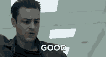 a man in a black jacket says good in a room