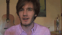 a man in a pink shirt is making a funny face