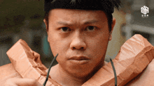 a man is wearing a black headband and a brown paper bag