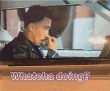 a tv screen shows a man in a car and the words whatcha doing below it