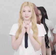 a woman with long blonde hair is wearing a white shirt and tie .