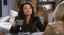 a woman is holding a cup of tea with a tag that says #indebted on it