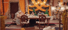 a group of people are sitting at a table with a starlife logo on the wall behind them