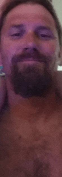 a man with a beard is brushing his teeth with a toothbrush in a bathroom .