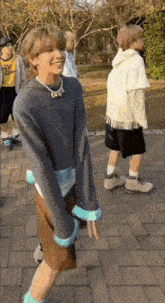a man in a sweater and shorts is standing on a sidewalk .