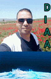 a man wearing sunglasses stands in front of a field of red flowers with the letters diaa above him