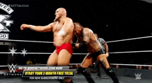 two men are wrestling in a wrestling ring with an advertisement for wwe network