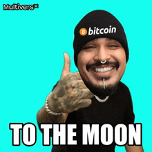 a man wearing a beanie that says bitcoin is giving a thumbs up
