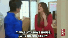 a woman is talking to another woman in a room while standing next to a door .