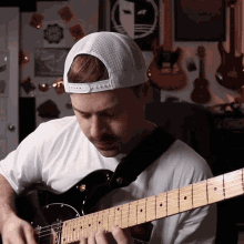 a man playing a guitar in front of a fender amp