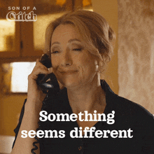 a woman talking on a phone with the words something seems different