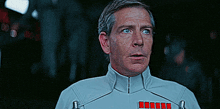 a man in a white uniform with red stripes on the sleeves looks surprised