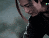 a close up of a man 's face with a ponytail