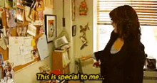 a woman is standing in a room with the words this is special to me written on the wall .